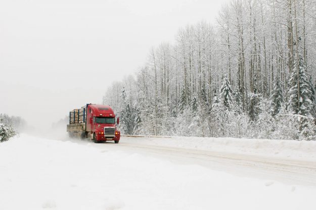 Red transport truck driving in winter