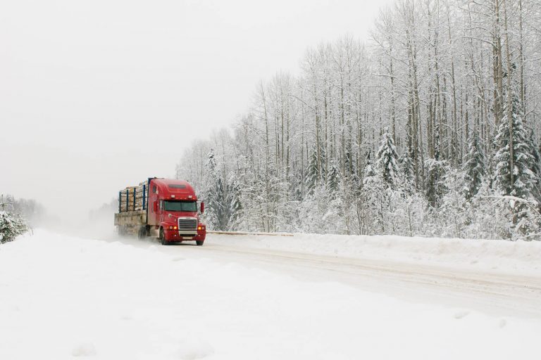 Red transport truck driving in winter